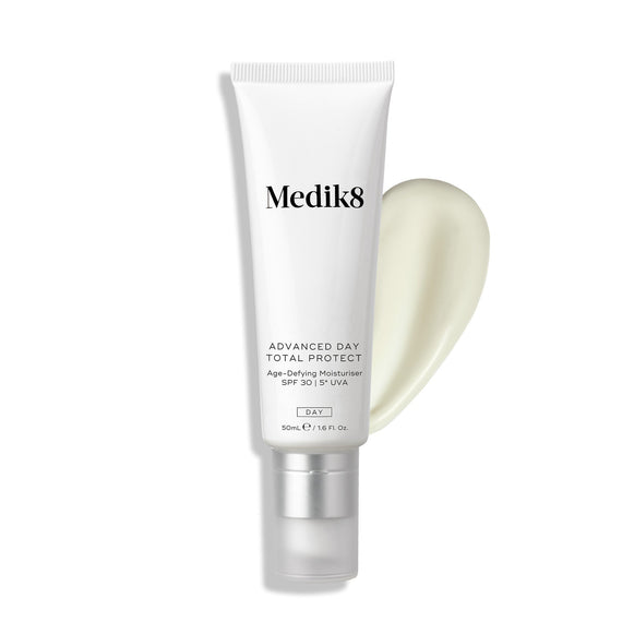 A white tube labeled "Advanced Day Total Protect™" by Medik8, featuring SPF 30, is displayed on a light background to emphasize its sunscreen capabilities. A small amount of cream, designed for environmental protection, is shown beside the tube.-