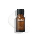 A brown bottle labeled "C-Tetra® Eye" from Medik8, topped with a black cap, stands against a white background. Its contents—a potent vitamin C serum for fine lines and wrinkles—are spilled underneath.