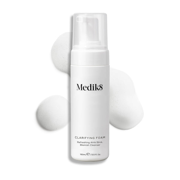 A 150ml bottle of Medik8's Clarifying Foam™, enriched with refreshing AHAs and BHAs, with foam bubbles elegantly surrounding it.