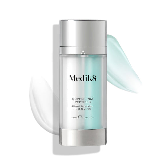 Medik8's Copper PCA Peptides™ serum, enriched with age-defying peptides, is showcased with visible white and light blue product smears in the background.-10