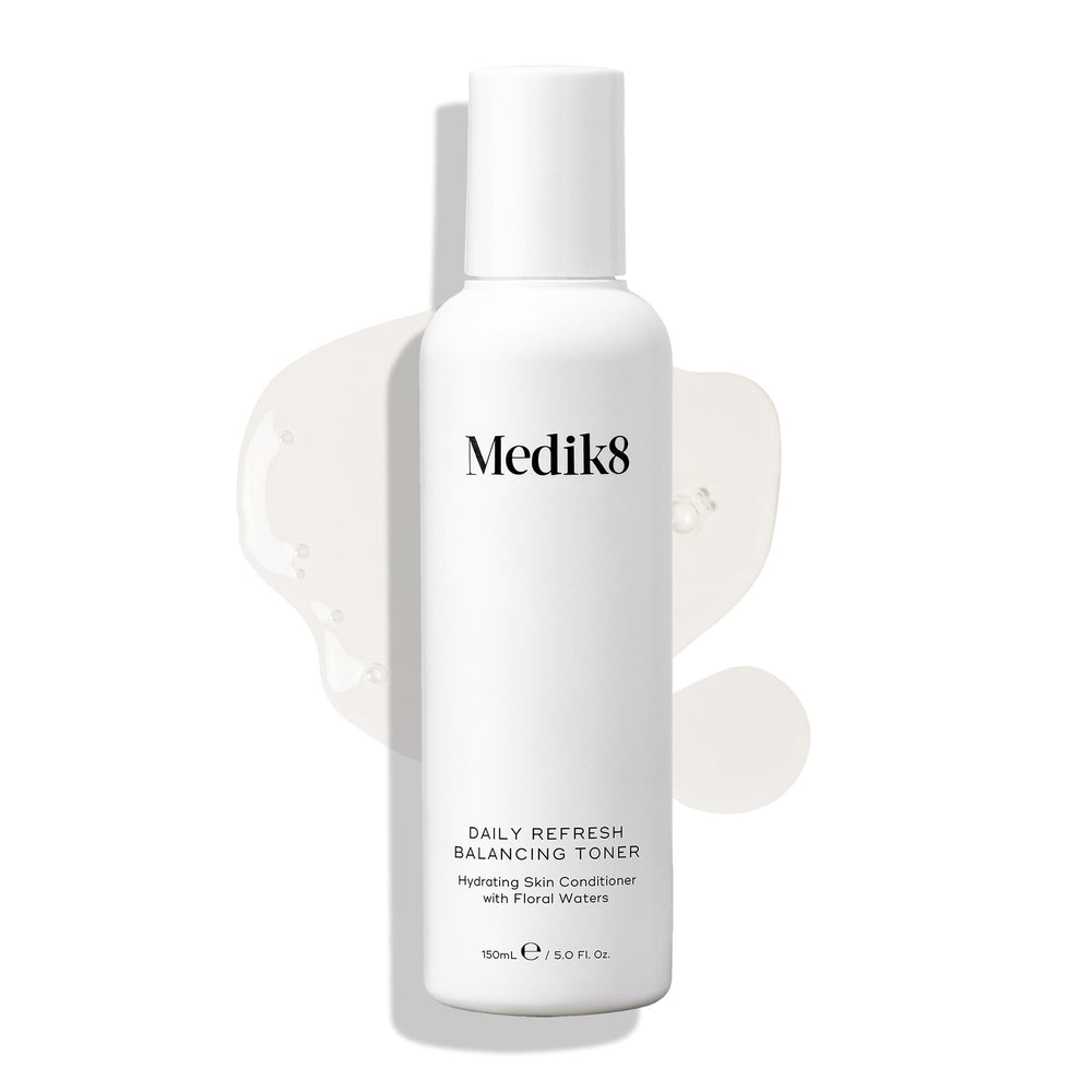 A white bottle of Medik8's Daily Refresh Balancing Toner™ displays black text with a light liquid splash on a white background, making it an ideal daily hydrator for your skin.