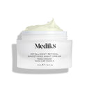 A jar of Medik8 Intelligent Retinol® Smoothing Night Cream, featuring 0.2% vitamin A, is displayed with the lid off, revealing the luxurious cream inside. This anti-aging moisturizer promises overnight complexion renewal for a youthful glow.