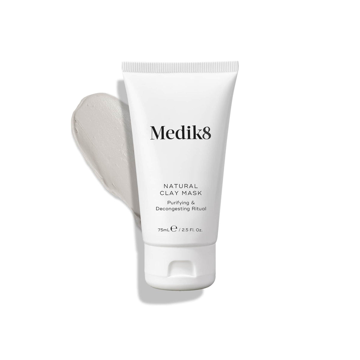 A white tube labeled "Natural Clay Mask™" from Medik8 with a gray cream swatch, featuring bentonite and kaolin clay to refine pores.