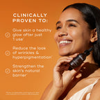 A smiling woman holds a C-Tetra® Luxe (Travel Size) bottle by Medik8 against an orange background. The text highlights benefits: glowing skin after one use, wrinkle and hyperpigmentation reduction, and strengthened skin barrier with radiance-boosting vitamin C.
