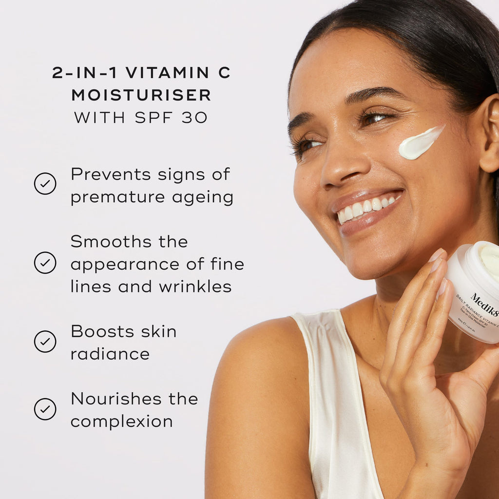 A smiling woman applies Medik8's Daily Radiance Vitamin C™, a 2-in-1 moisturizer with SPF 30. Text highlights benefits: prevents aging, smooths lines, boosts radiance, and nourishes skin with potent antioxidant protection.