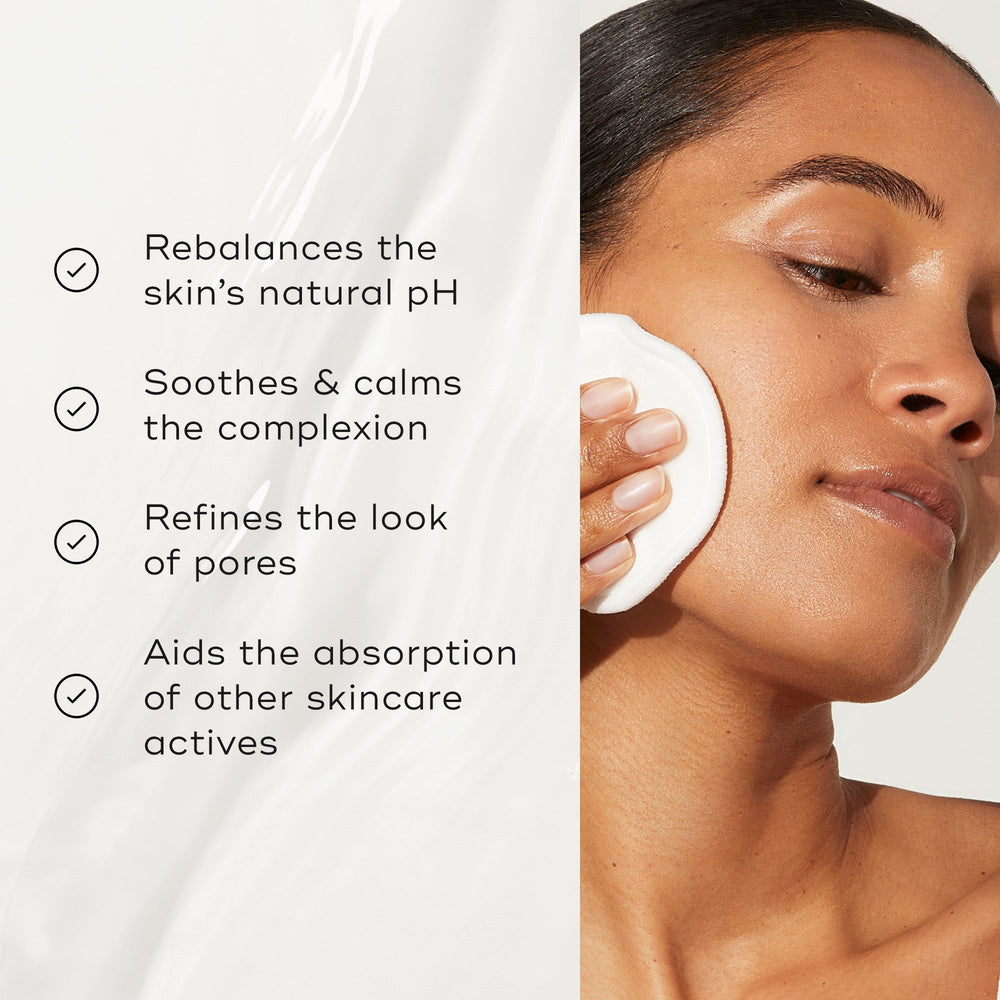 A person applies Medik8's Daily Refresh Balancing Toner™ with a cotton pad to rebalance pH, soothe complexion, refine pores, and enhance absorption of skincare actives for effective skin hydration.