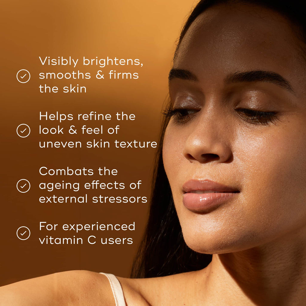 A woman uses Medik8's Pure C15™ serum against an orange backdrop, noted for its skin-brightening, texture-refining, antioxidant-protective properties that combat aging effects—perfect for experienced users.