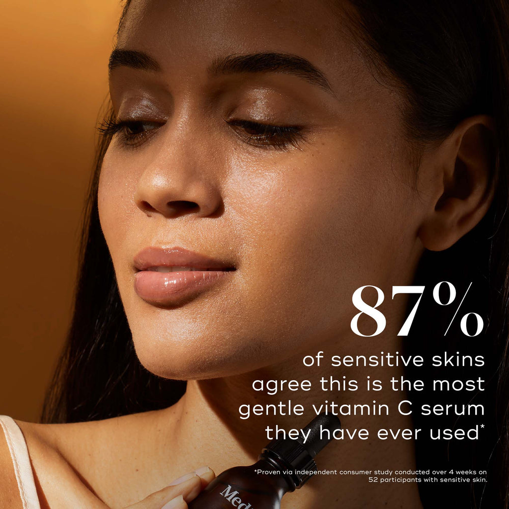 A woman applies Medik8's C-Tetra® serum against an orange background. Text overlay highlights that 87% of users with sensitive skin find C-Tetra® the gentlest vitamin C serum, enhancing skin radiance.