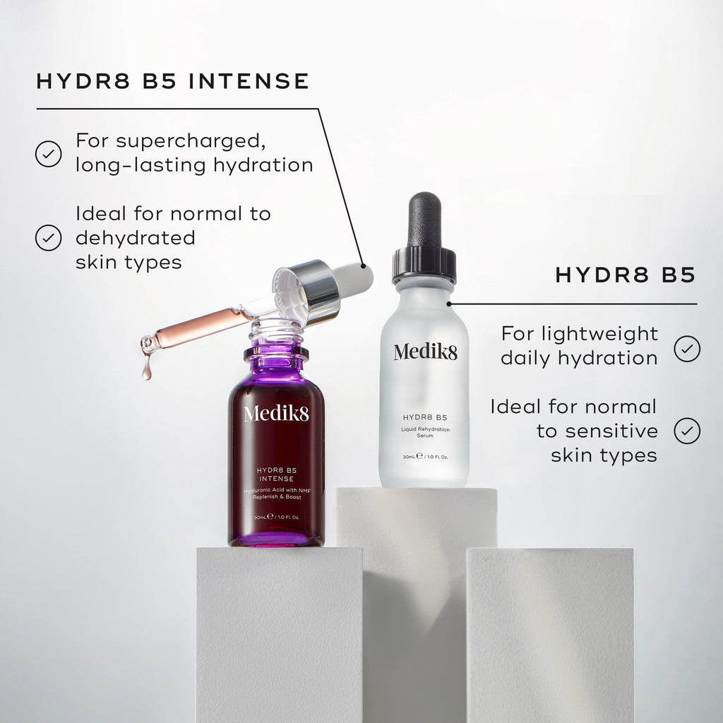 Two Medik8 skincare bottles with droppers, Hydr8 B5™ (Travel Size) and HYDR8 B5 Intense, sit elegantly on white pedestals. Each moisturizing serum provides targeted hydration, catering to diverse skin needs.
