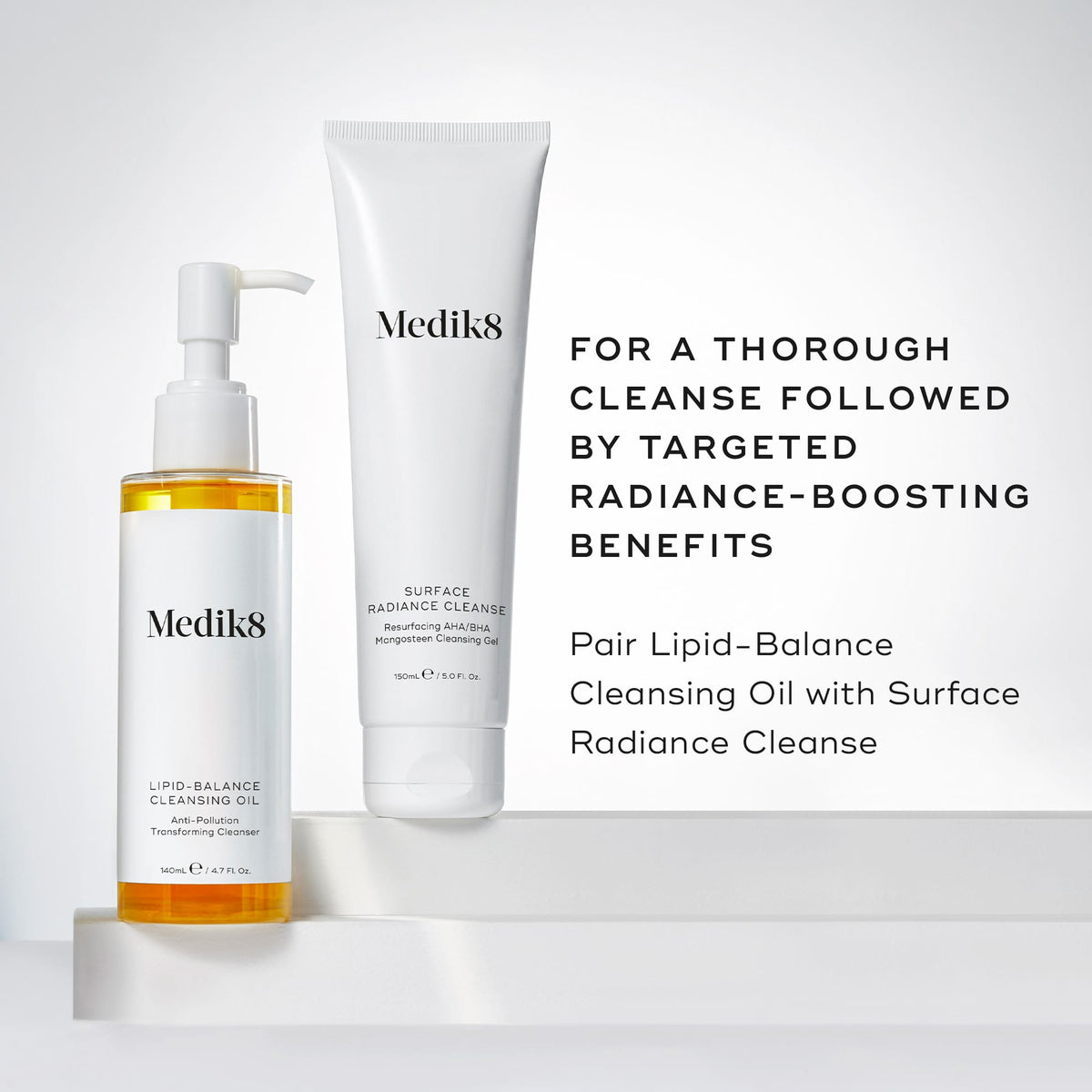 Medik8's Lipid-Balance Cleansing Oil™ and Surface Radiance Cleanse are elegantly arranged on a white backdrop, highlighting their makeup removal and anti-pollution benefits. Transform your skincare routine with these radiance-boosting products.