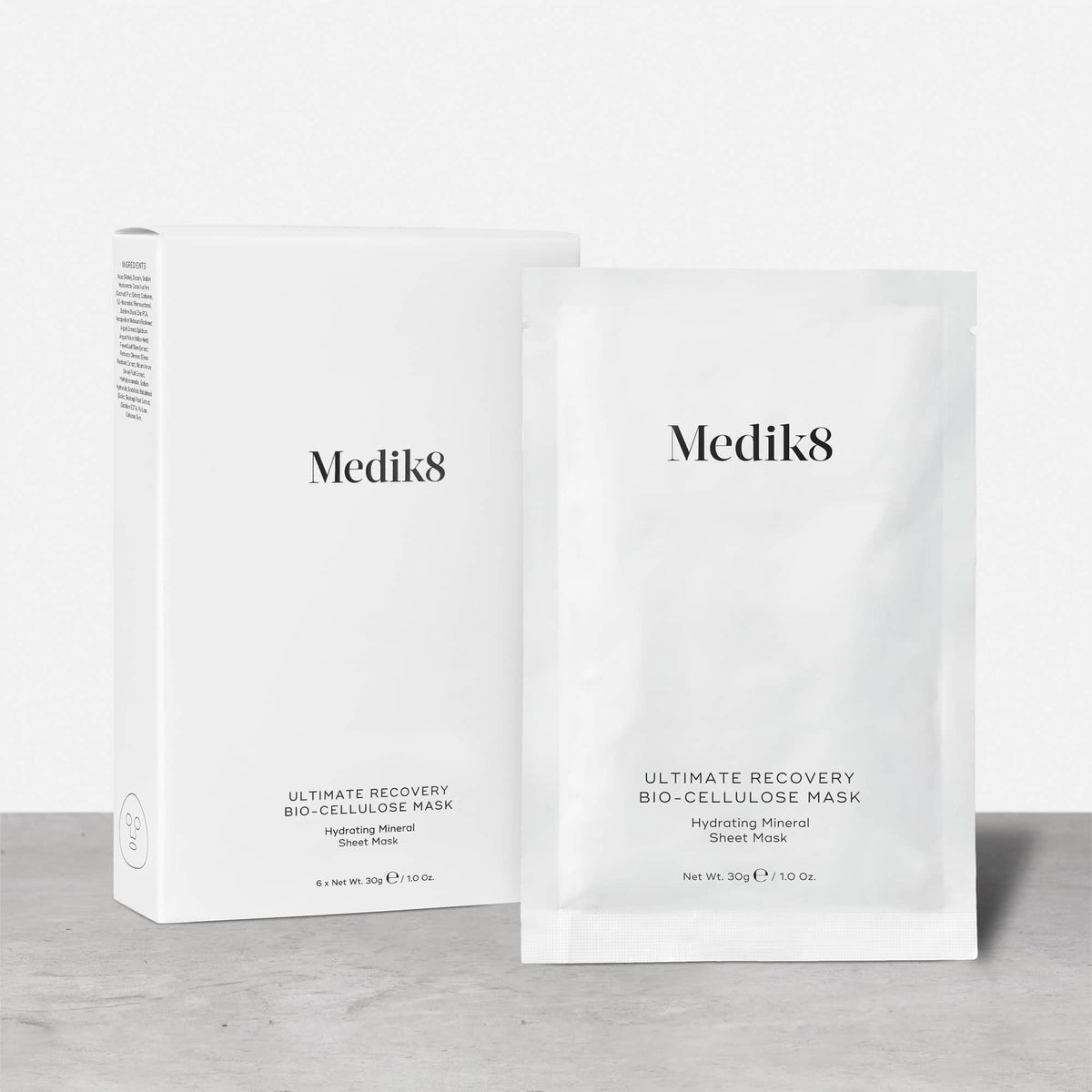 The Medik8 Ultimate Recovery™ Bio-Cellulose Mask features white packaging and a sachet with a minimalist design. Ideal for sensitive skin, this hydrating mineral sheet mask offers a soothing experience.