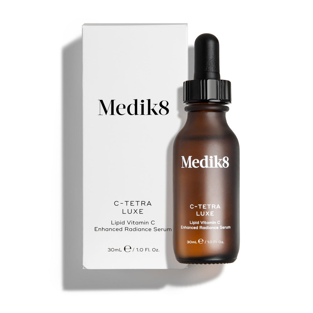 A brown dropper bottle labeled "Medik8 C-Tetra® Luxe" is displayed next to its white box packaging. It contains 30ml of lipid vitamin C, designed to boost skin radiance and provide antioxidant protection.