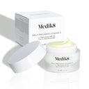 An open jar of Medik8's Daily Radiance Vitamin C™ cream reveals its light yellow contents, offering SPF 30 and antioxidant protection, with the product box in the background.