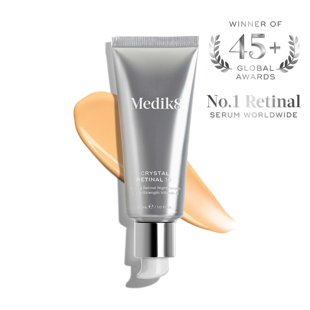 A silver tube of Medik8’s Crystal Retinal® is shown with an orange cream smear, award badge, and text stating it's the world’s No. 1 retinal serum, boasting 45+ global awards.