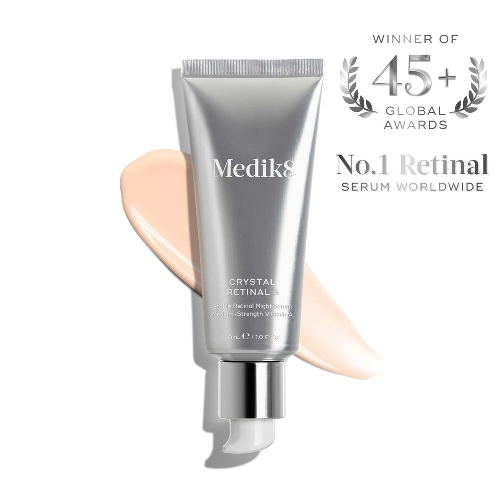 A silver tube of Medik8 Crystal Retinal®, the No.1 retinal and vitamin A night serum worldwide with 45+ global awards, alongside a product smear.