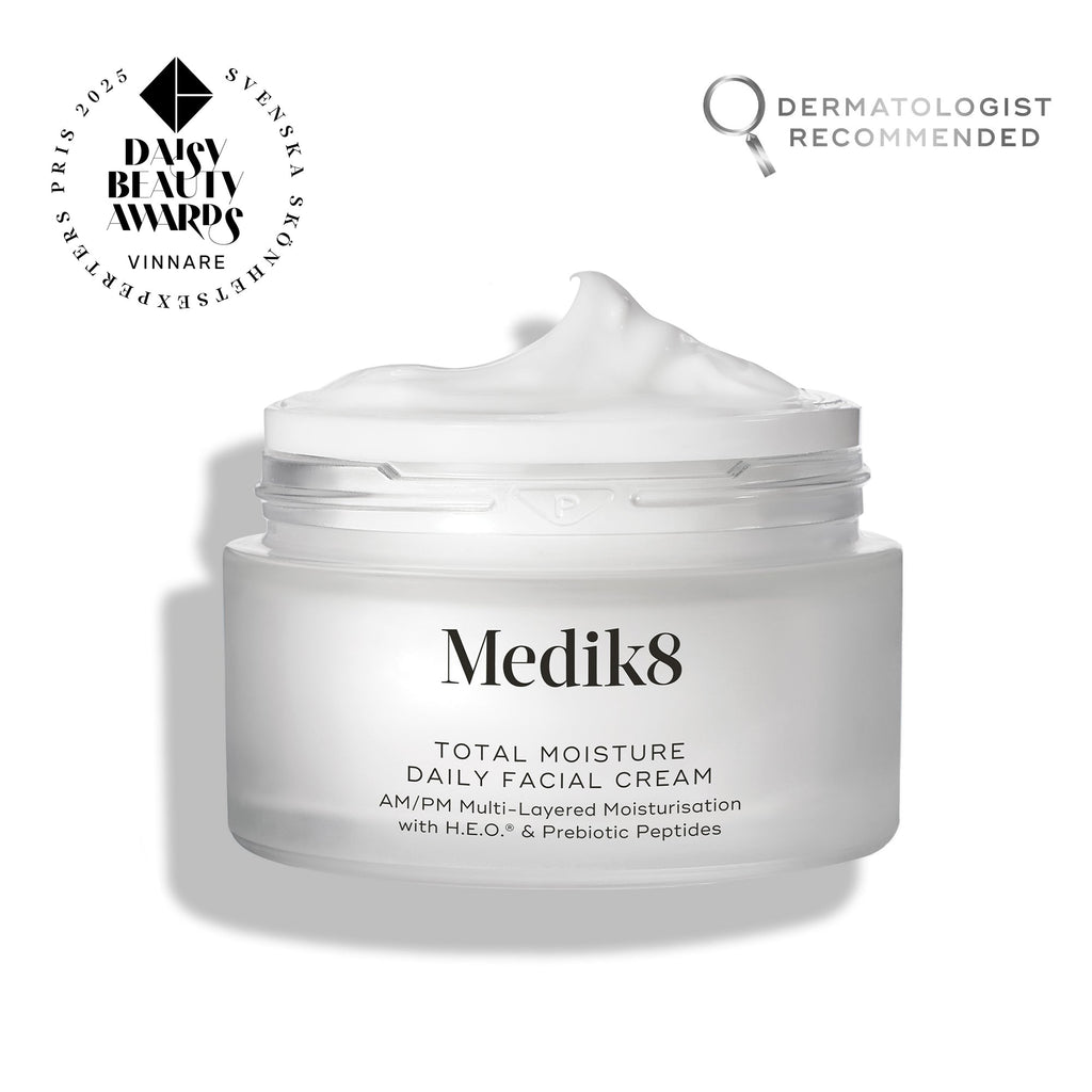 A jar of Medik8 Total Moisture Daily Facial Cream™ with the lid off, showing the cream inside and award plus dermatologist recommended badges behind. Contains hyaluronic acid to support your skin barrier as a daily moisturiser.