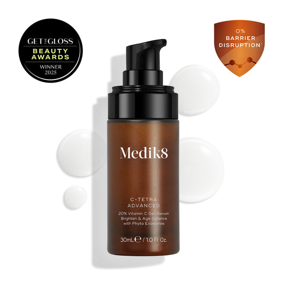 A bottle of Medik8 Cyprus C-Tetra® Advanced vitamin C serum with pump, product drops, an award badge, and a "0% Barrier Disruption" badge on a white background for skin brightening and anti-ageing.