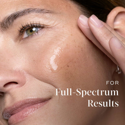 A close-up of a woman's face with Medik8 Cyprus Exo-PDRN Prismatic+ applied to her cheek, accompanied by the text "For Full-Spectrum Results.