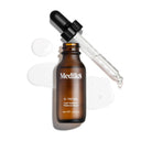 A brown bottle labeled "C-Tetra®" by Medik8, with a black dropper, is displayed on a white background alongside clear liquid drops. This vitamin C-rich antioxidant serum enhances skin radiance.