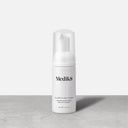 A Medik8 Clarifying Foam™ Blemish Cleanser in a white bottle with powerful AHAs and BHAs has a clear cap, set on a gray surface against a white background.
