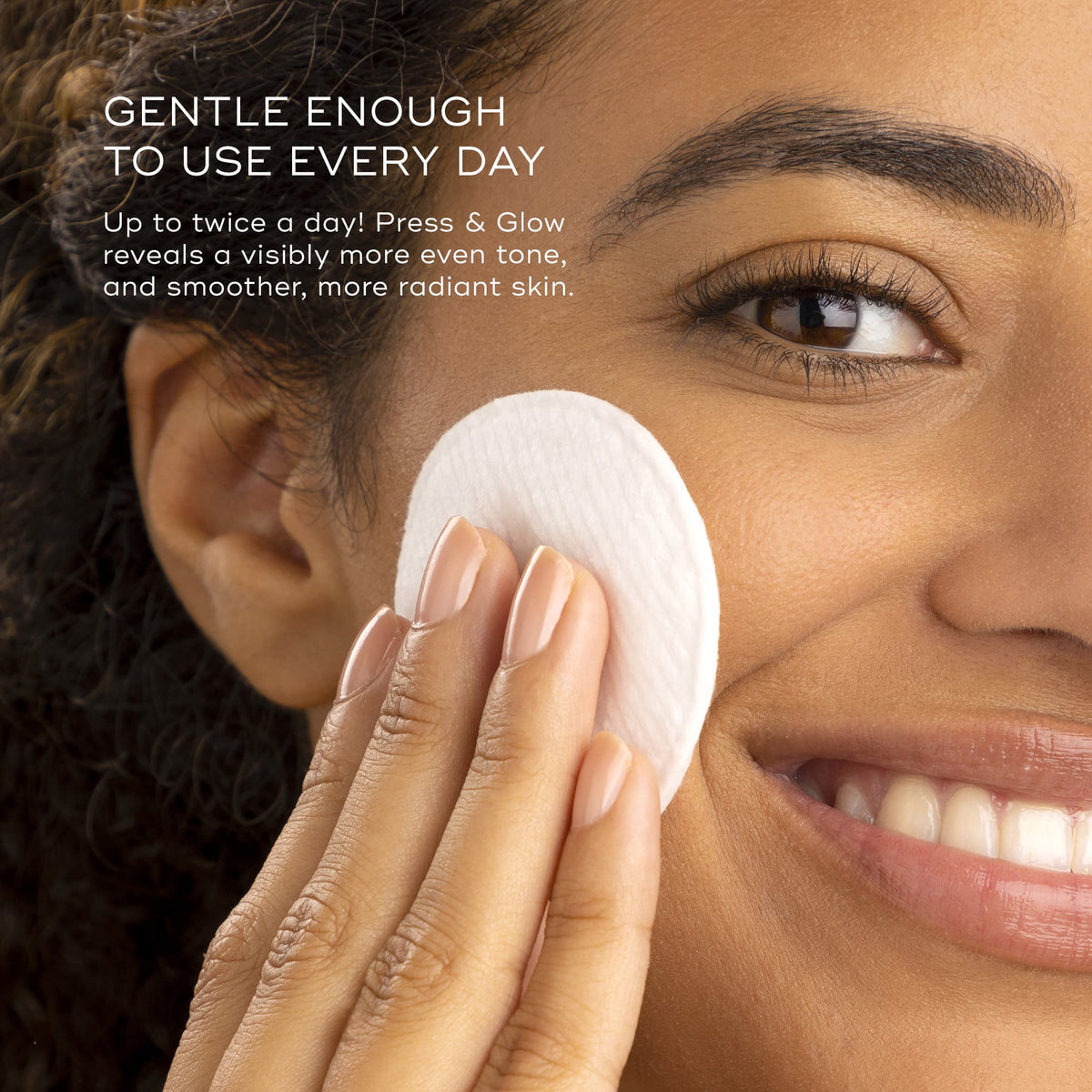 A smiling person holds a cotton pad to their face. Text: "Press & Glow Refill™ by Medik8 is gentle for sensitive skin. Use twice daily! Infused with exfoliating poly hydroxy acids for a smoother, more radiant complexion and even tone.